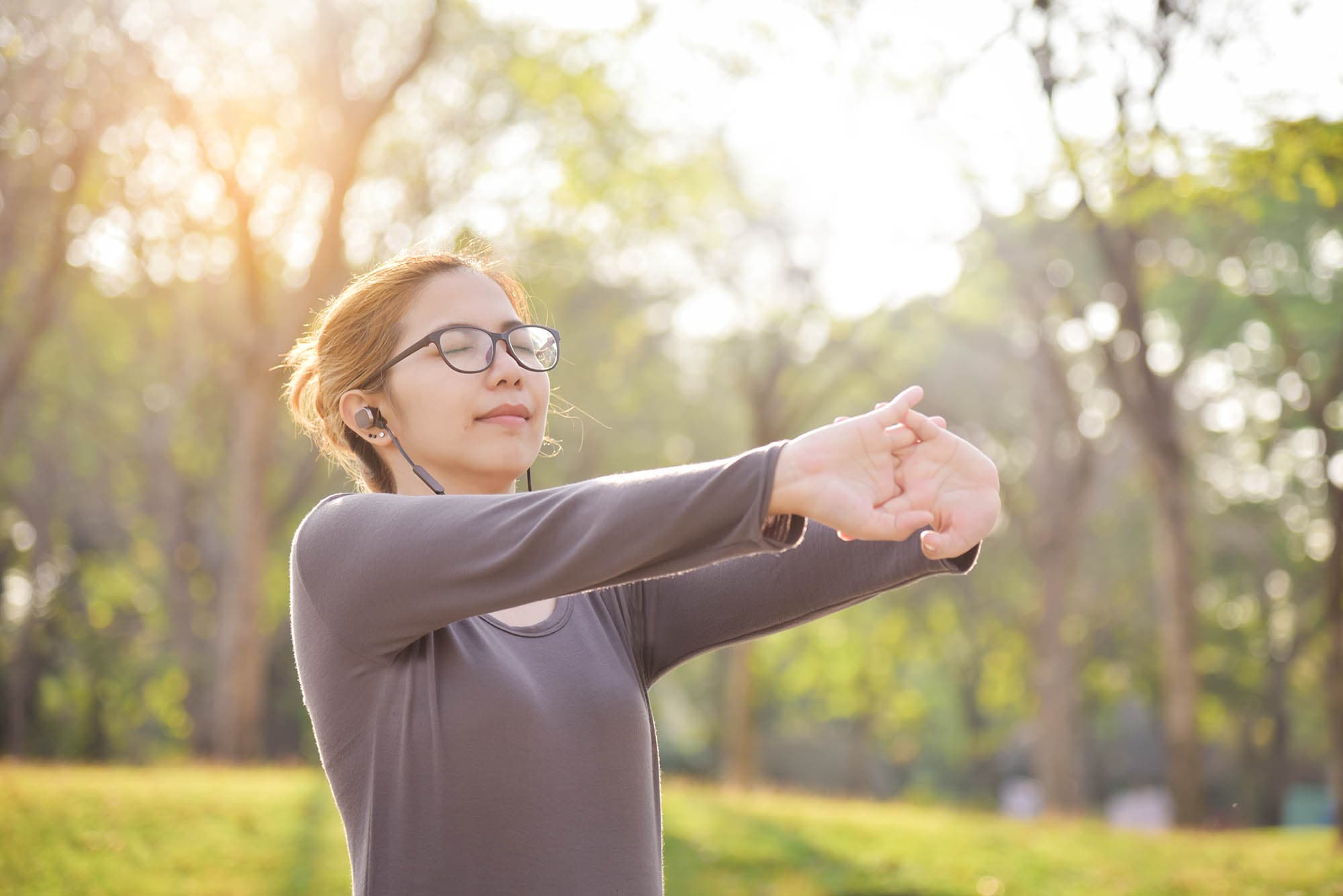 young-asian-woman-stretching-in-the-park